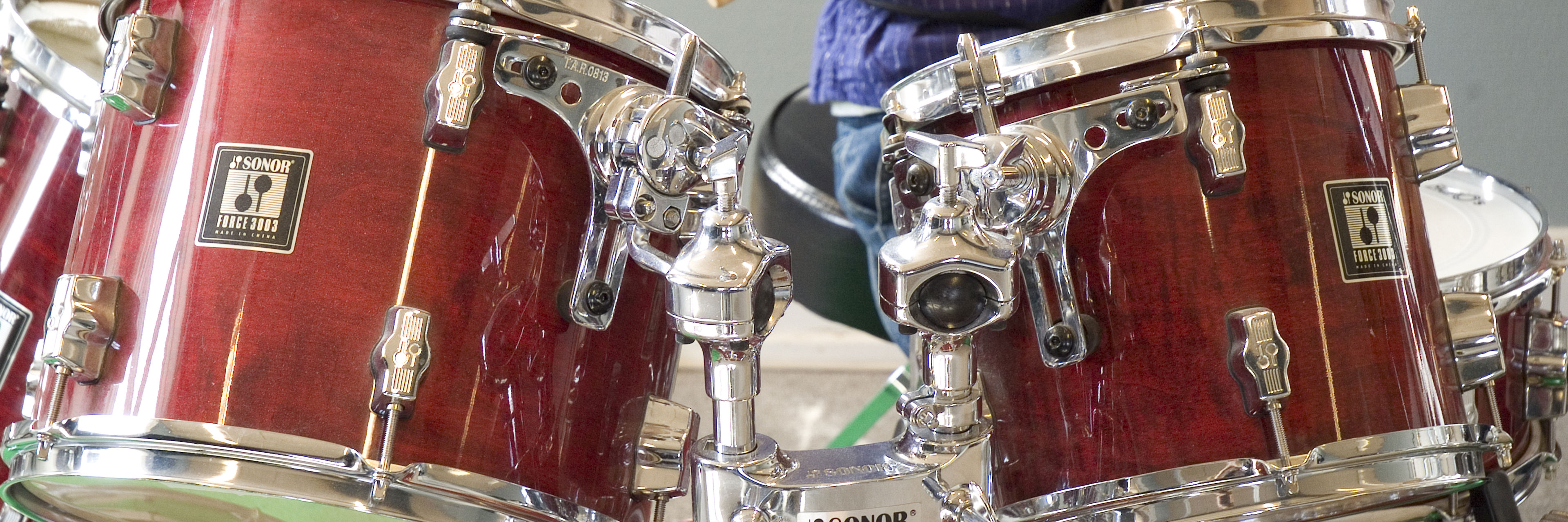 Dreng der spiller på et trommesæt