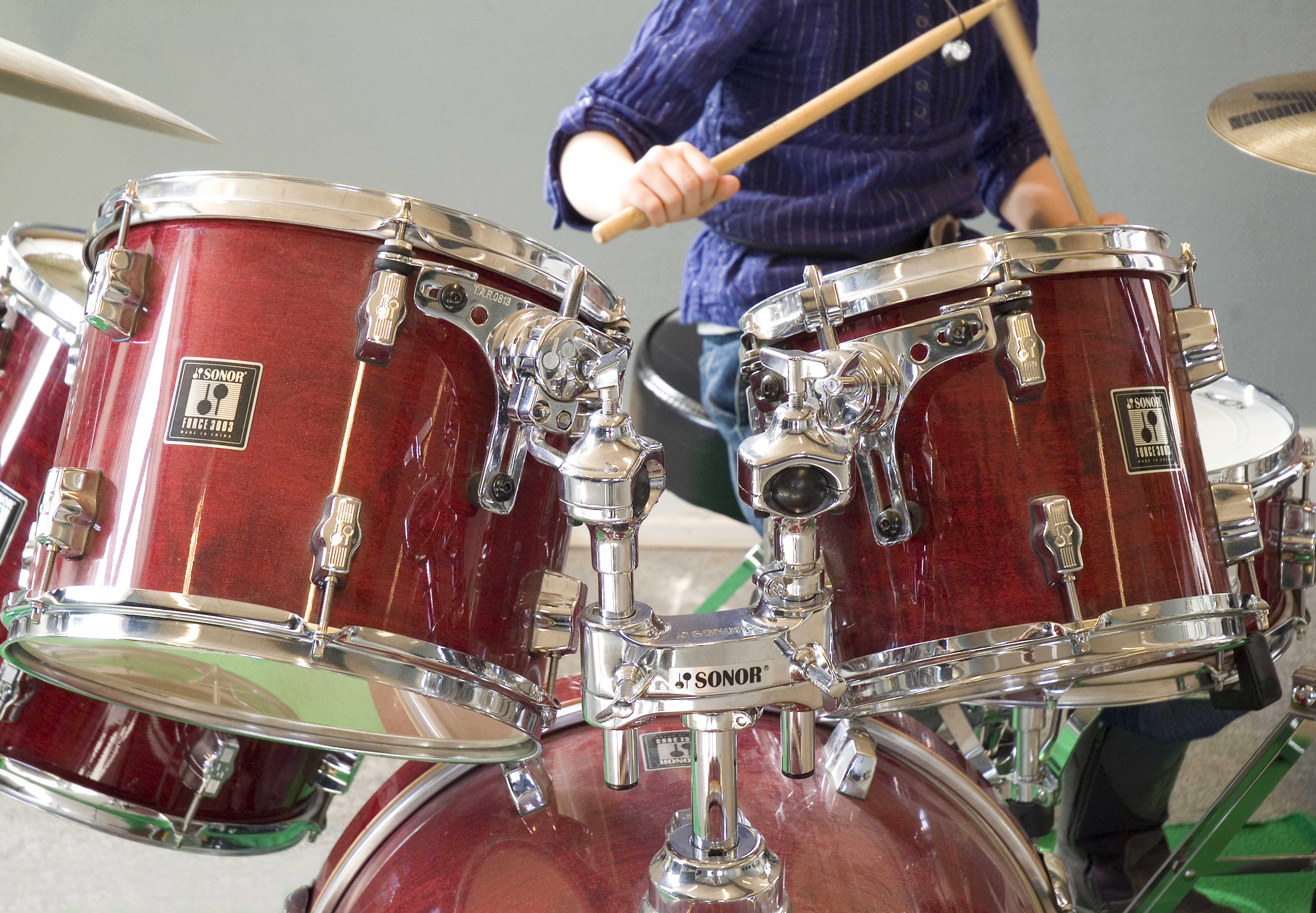 Dreng der spiller på et trommesæt